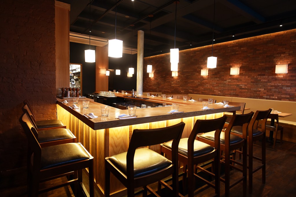 A bar setting with chairs and ambient lighting