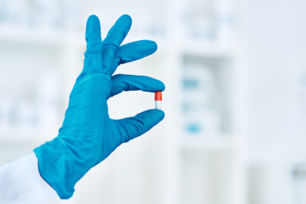 Unrecognizable female scientist in laboratory holding up a tablet that simulates health benefits of long-distance running