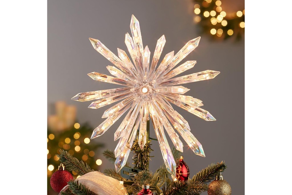 A lit up Christmas tree topper crystal