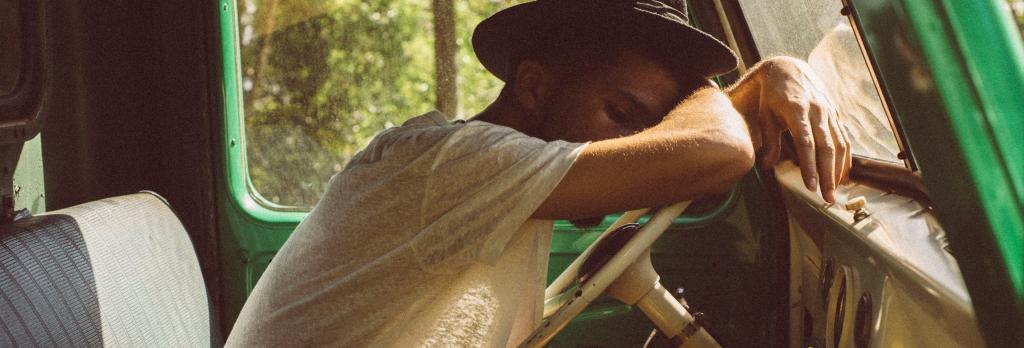 A man sleeping on a steering wheel