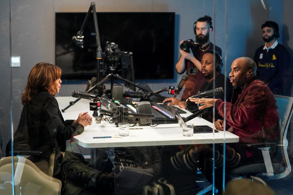 Democratic presidential nominee Kamala Harris participating in town hall discussion with radio host Charlamagne Tha God and others, seated at table with microphones in Detroit, Michigan