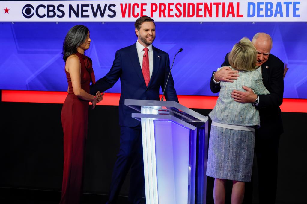 Minnesota Gov. Tim Walz hugs his wife Gwen Walz as Senator JD Vance and his wife Usha Vance look on following the Vice Presidential debate on Oct. 1, 2024.