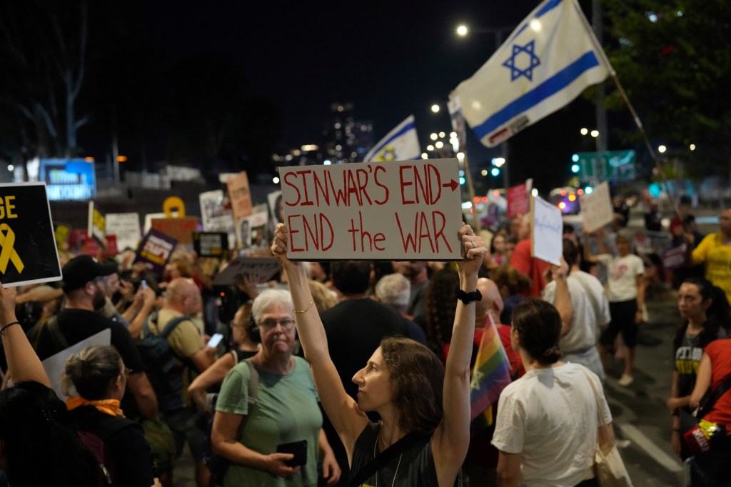 A demonstrator holding a sign calling for the war in Gaza to end after the death of Sinwar.