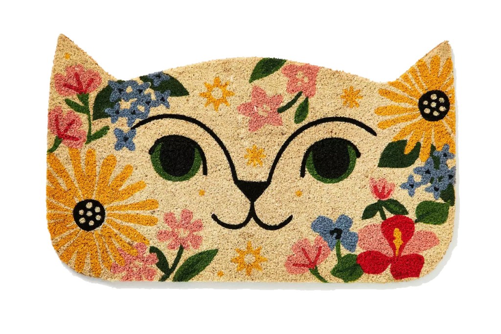 A doormat with a design of a cat face surrounded by flowers