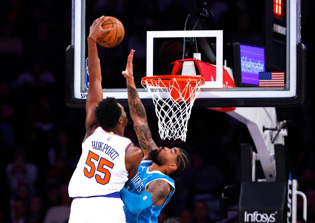 New York Knicks center Ariel Hukporti dunking a basketball against Charlotte Hornets center Nick Richards during a preseason basketball game at Madison Square Garden