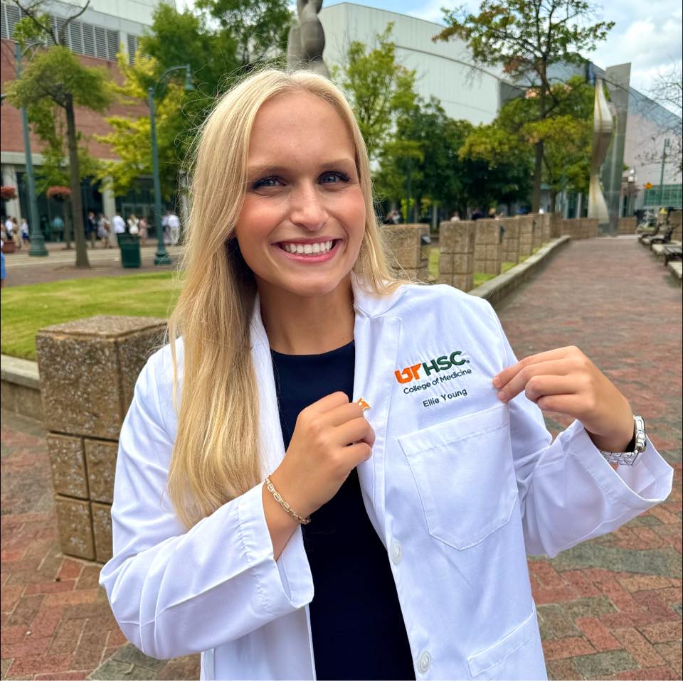 Ellie Claire Young posing in her white doctor's coat.