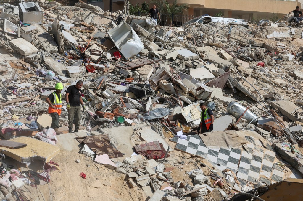 Emergency personnel work at the site of Sunday's Israeli attack on the city of Ain Deleb.