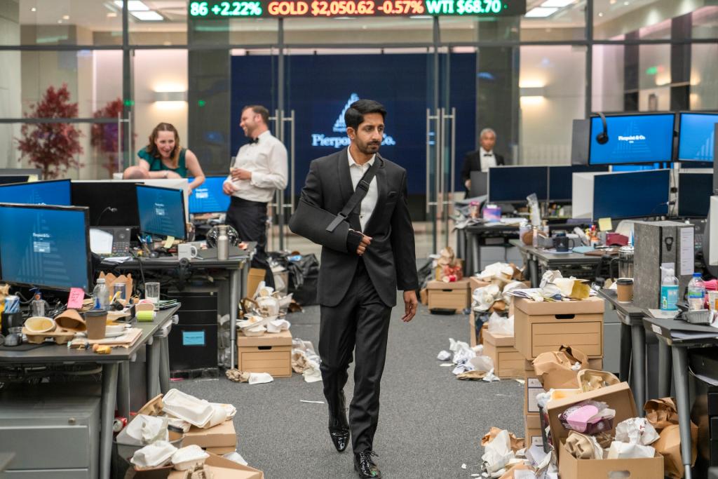 Man walking through wrecked office in sling, from "Industry" tv show.