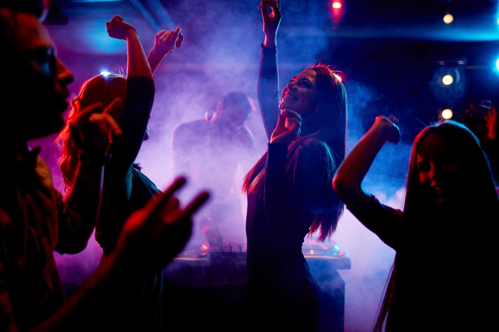 Group of young people dancing and enjoying their night at a disco club
