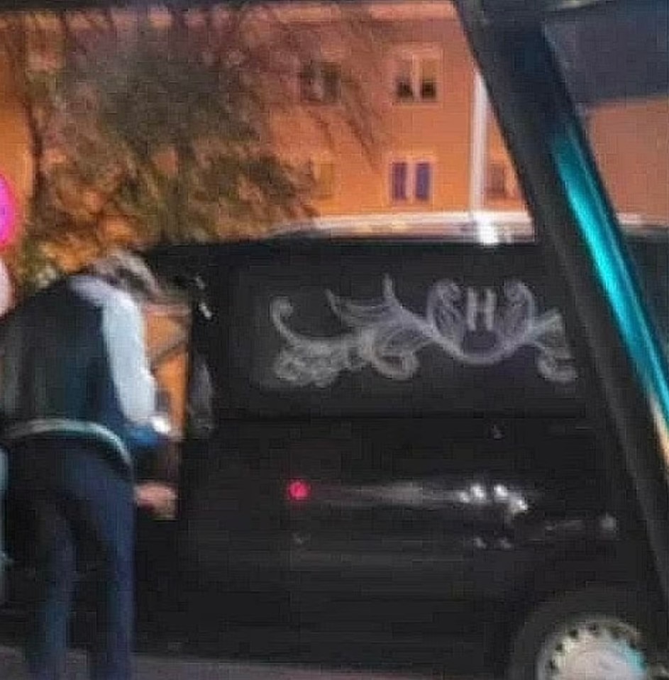 A man standing next to a Hades Funeral Services hearse in Poland