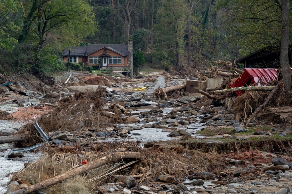 Destroyed homes and roads in Bat Cave, North Carolina after the aftermath of Hurricane Helene, with stream of water and debris