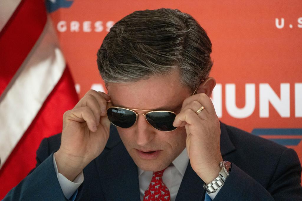 House Speaker Mike Johnson puts on a pair of Aviator sunglasses provided by the Nunn campaign during a campaign stop for U.S. Rep. Zach Nunn on Friday, Oct. 18, 2024, in West Des Moines.