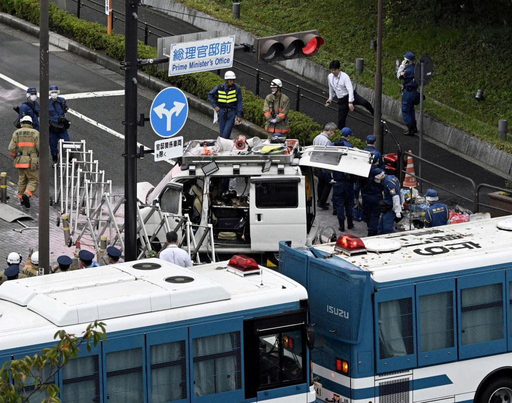 Police investigate a car stuck in a fence near the entrance to the Japanese Prime Minister's Office in Tokyo on Oct. 19, 2024.