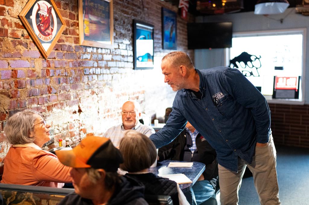 Osborn shaking hands with customers at Sly's Family Bar and Grill.