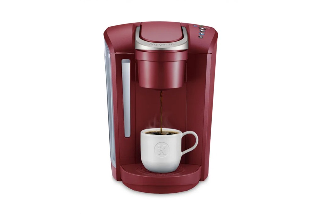 A red Keurig coffee maker with a cup of coffee