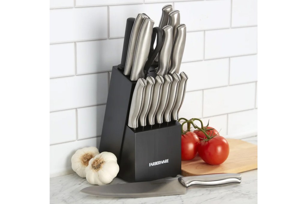 A knife block with a knife and another knife next to tomatoes