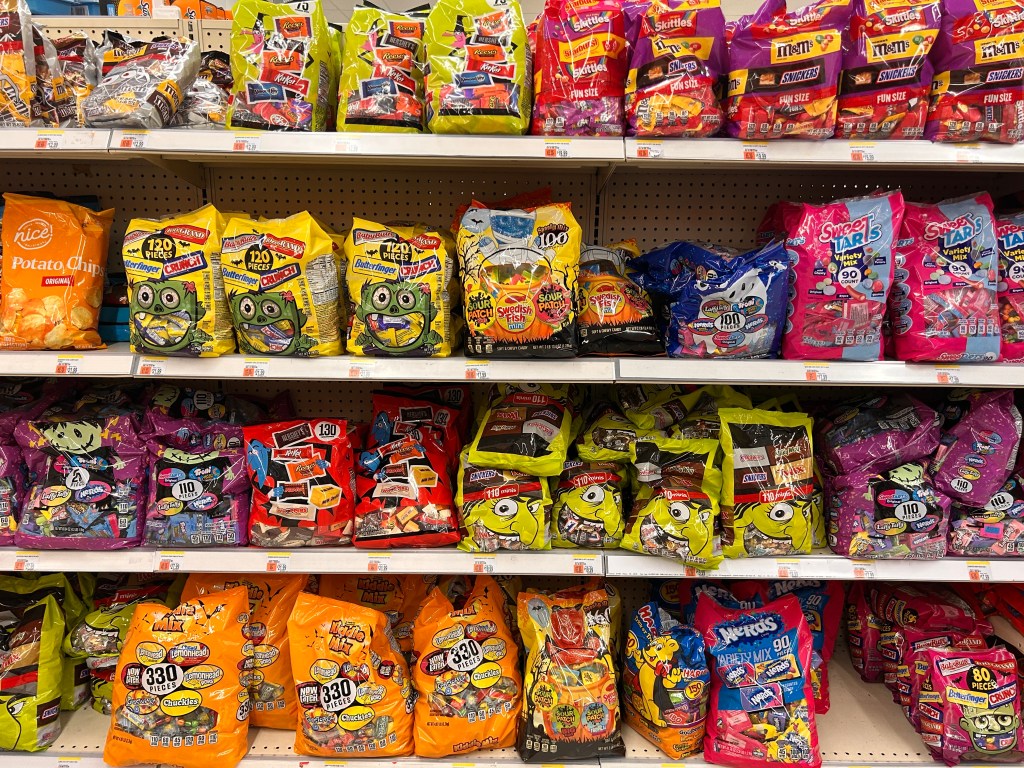 Large bags of assorted Halloween candy displayed for sale on a shelf in Walgreens pharmacy in Queens, New York