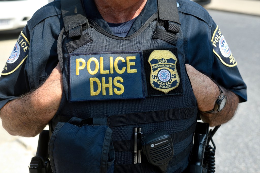 A Homeland Security officer in uniform is pictured.