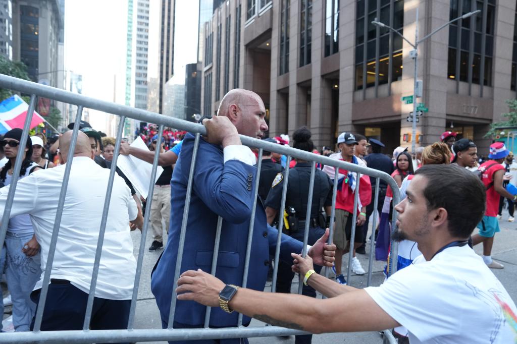 A man moves barriers during the Dominican Day Parade. 