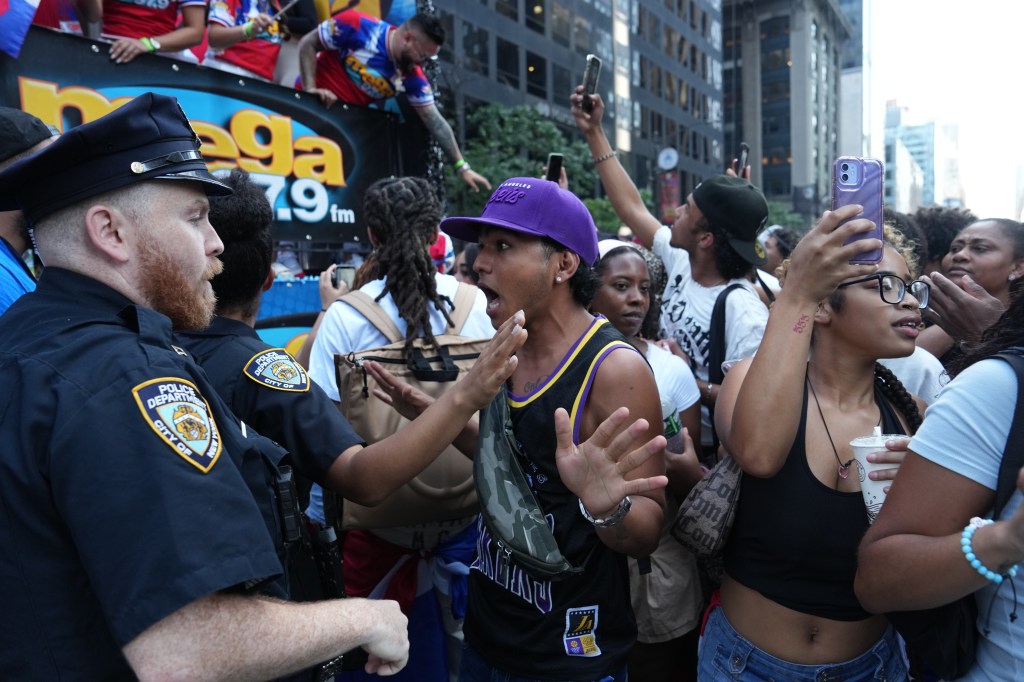 A woman argues with police during the Dominican Day Parade. 