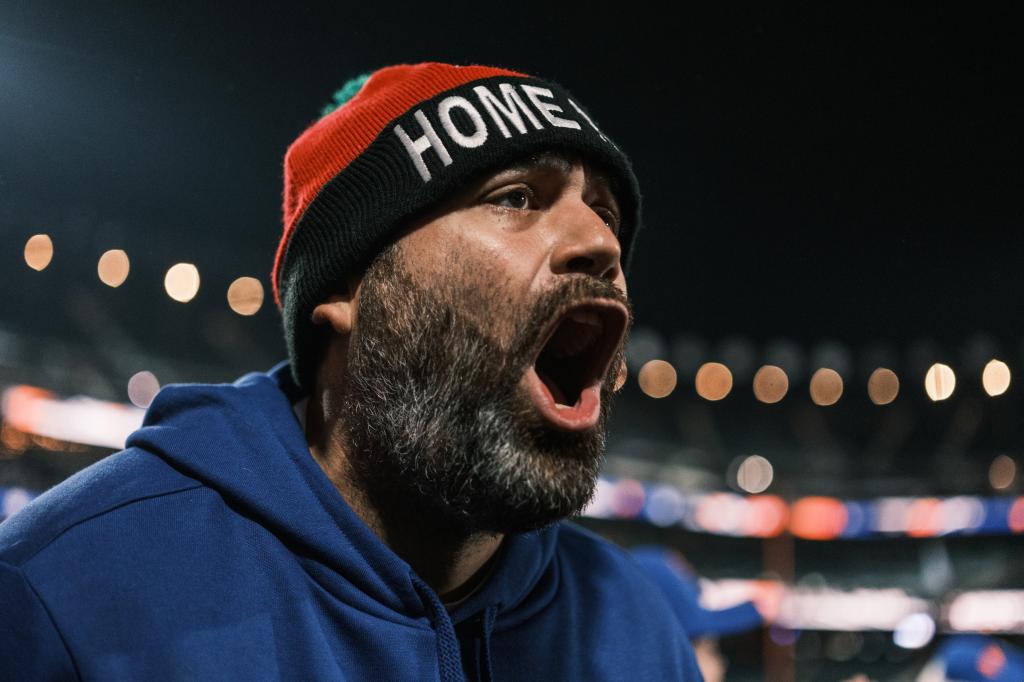 A fanatic wearing a "Home Run Apple" hat yells during the watch party at Citi Field.