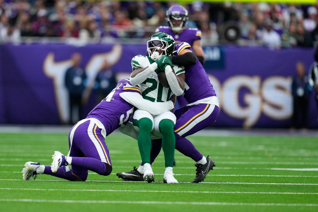 New York Jets' Breece Hall, center, is tackled by Minnesota Vikings defenders during the first half of an NFL football game, Sunday, Oct. 6, 2024, at the Tottenham Hotspur stadium in London.