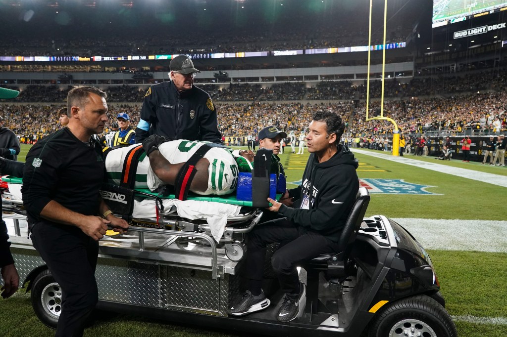 Jets guard Xavier Newman is carted off the field after being injured in the second half