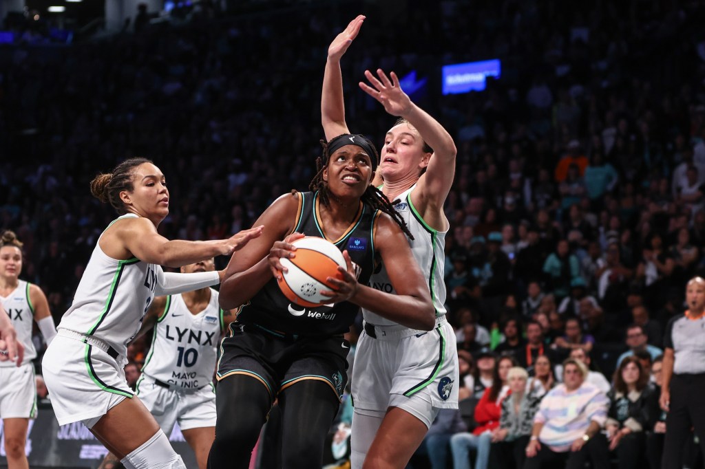 Liberty forward Jonquel Jones (35) looks to drive past Minnesota Lynx forwards Napheesa Collier (24)and Alanna Smith 