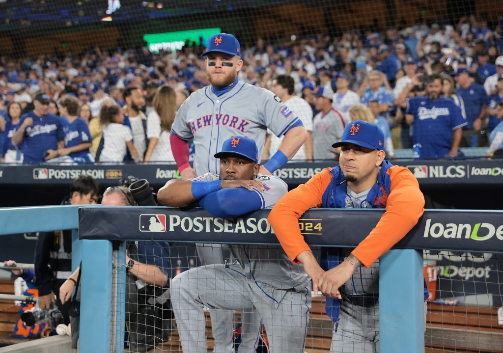 Harrison Bader, Starling Marte and Jose Butto reman in the dugout as the Los Angeles Dodgers celebrate clinching the NLCS.