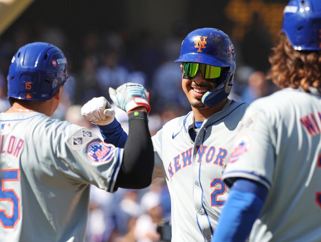 New York Mets third baseman Mark Vientos #27 high-fiving right fielder Tyrone Taylor #15 after hitting a grand slam homer during the NLCS Game 1 against the Los Angeles Dodgers at Dodger Stadium