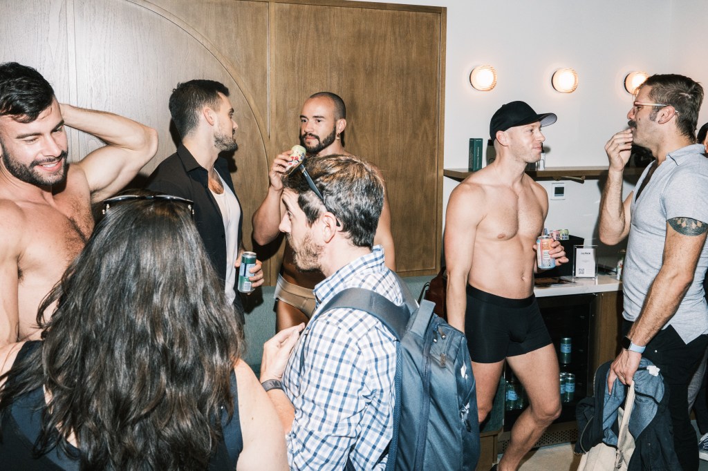 A group of men trying on and purchasing underwear at ALPHX's Tupperware party in New York, NY on September 26, 2024