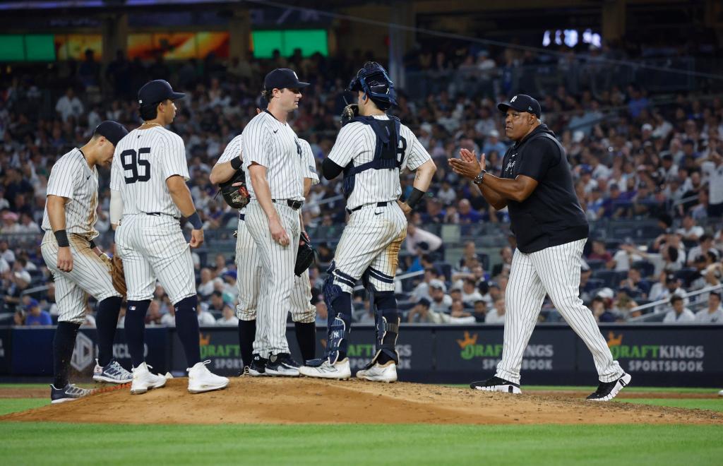 New York Yankees coach Mike Harkey walks to the mound to talk with New York Yankees starting pitcher Gerrit Cole #45, in the 6th inning.