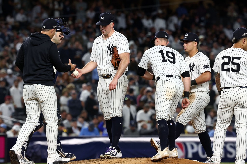 Yankees pitcher Carlos Rodon hands the ball to manager Aaron Boone as he's removed from Game 2 of the ALDS against the Royals in the fourth inning on Oct. 7, 2024.