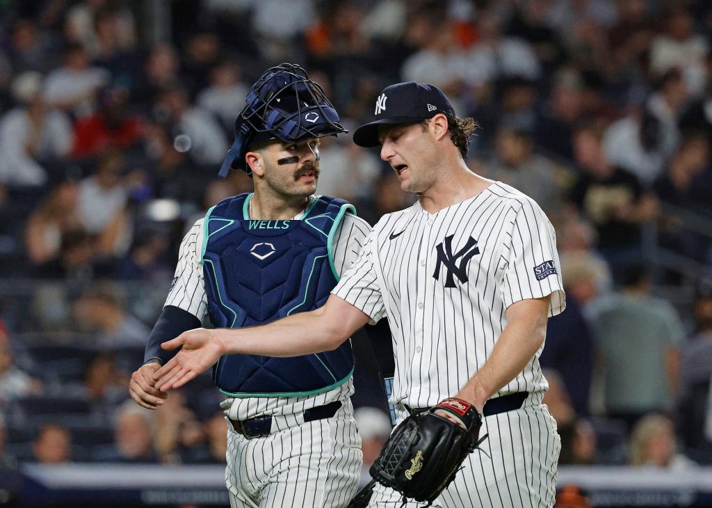 New York Yankees starting pitcher Gerrit Cole #45 speaks with New York Yankees catcher Austin Wells #28 as they walk back to the dugout after ending the third inning.