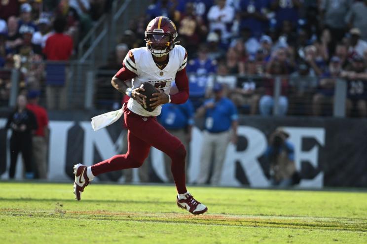 Washington Commanders quarterback Jayden Daniels (5) rolls out to pass during the second half against the Baltimore Ravens at M&T Bank Stadium.