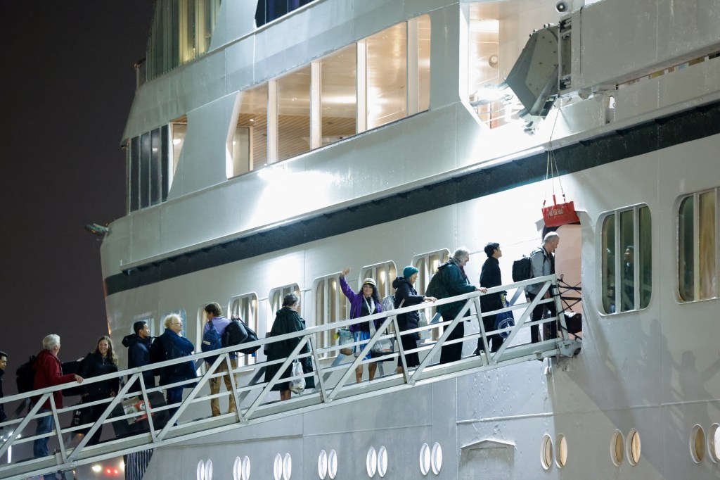 Passengers board the Villa Vie Residences' 'Odyssey' cruise ship, which has been stranded in Belfast since May 2024