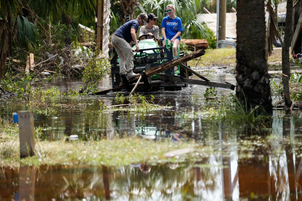 People move debris from a damaged home in the aftermath of Hurricane Helene, in Horseshoe Beach, Fla. on Sept. 28.