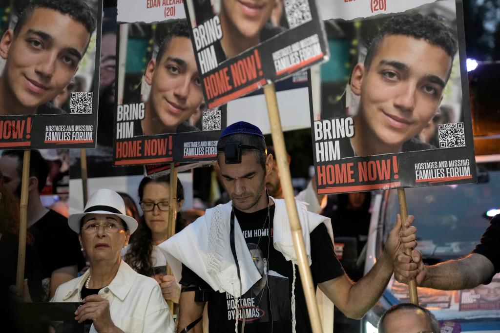 Group of protestors holding signs outside Prime Minister Benjamin Netanyahu's house on the one-year anniversary of the Hamas attack on Israel