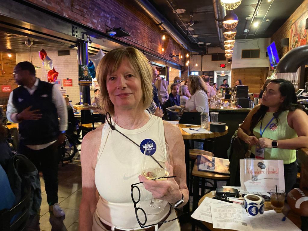 Ellen Ochs holds a wine glass at a Democratic VP debate watch party in Pittsburgh.