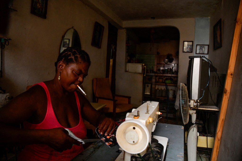 Reina Carriera, 57, waits for the return on electricity for her sewing machine during a blackout in Havana, Cuba, October 17, 2024.