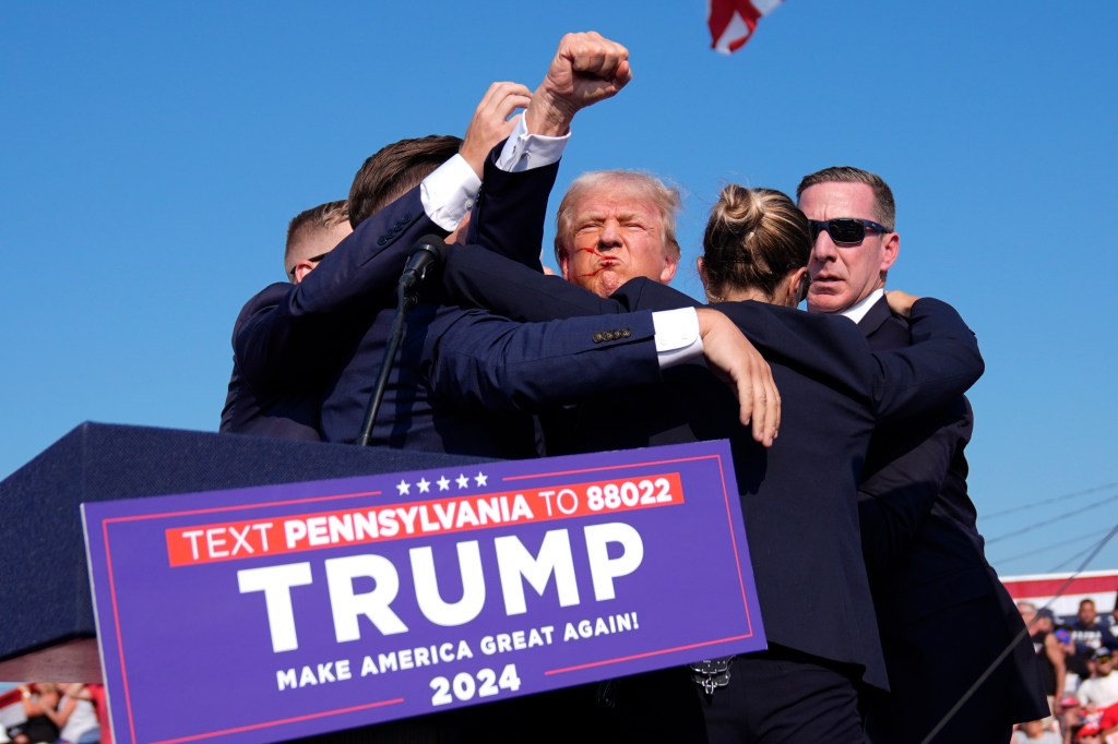 Former President Donald Trump, the republican presidential candidate, surrounded by U.S. Secret Service agents, gesturing at a campaign rally in Butler, Pa on July 13, 2024