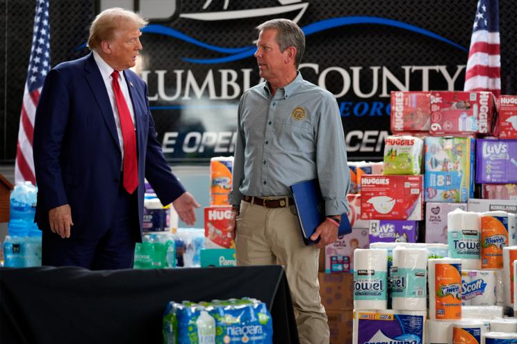 Former President Donald Trump discussing with Georgia Governor Brian Kemp at a relief shelter in areas affected by Hurricane Helene