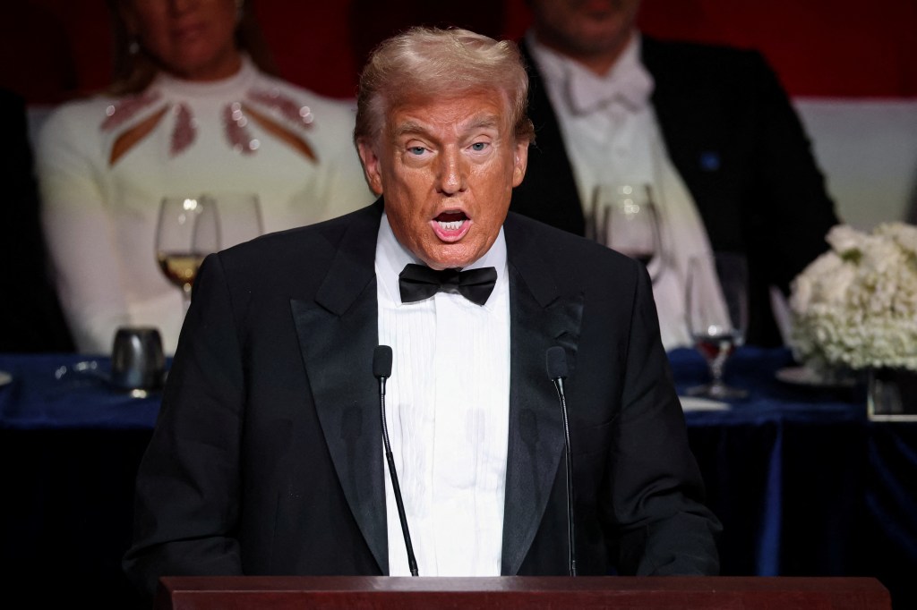 Former U.S. President Donald Trump, in a tuxedo, speaking into a microphone at the 79th annual Alfred E. Smith Memorial Foundation Dinner in New York City, October 17, 2024.