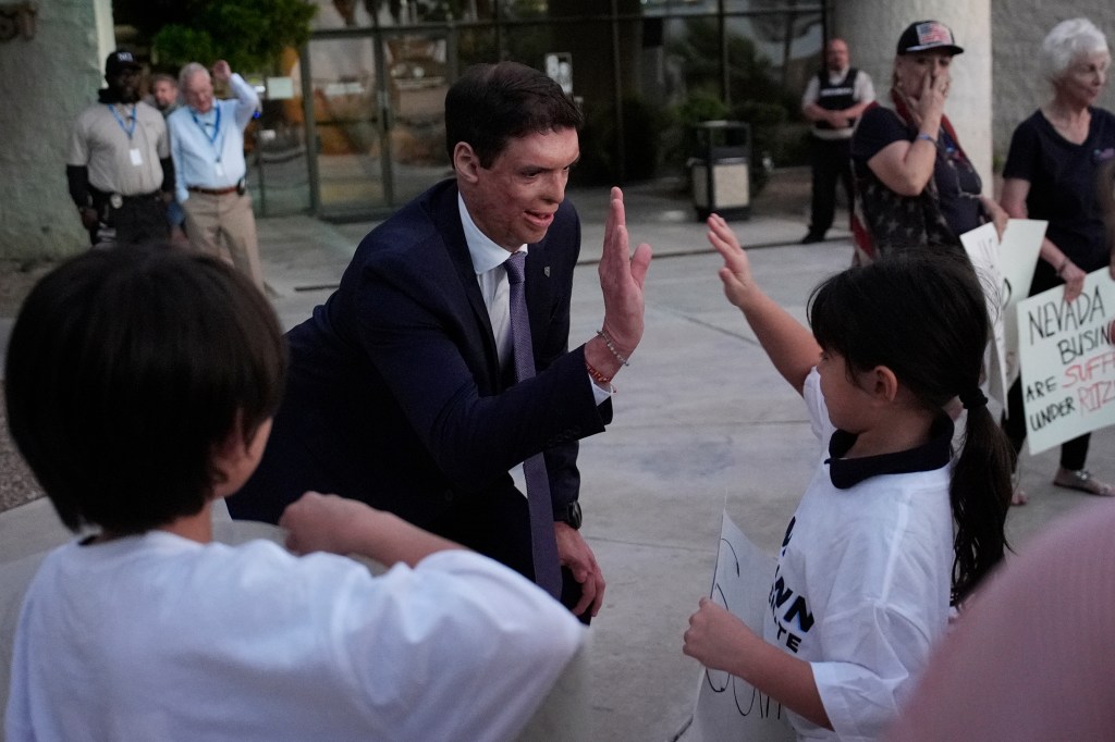 Republican Senate candidate Sam Brown in a suit and tie, meeting and high-fiving supporters before his 2024 Nevada Senate Debate against Sen. Jacky Rosen.