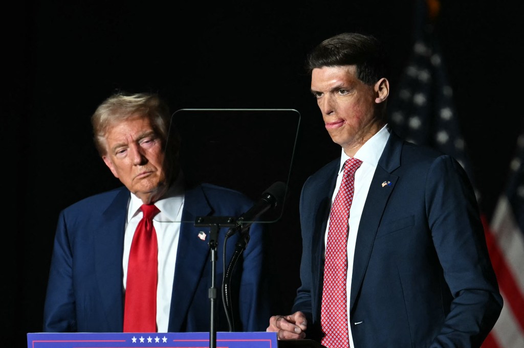 Republican US Senate candidate Sam Brown speaking on stage alongside former President Donald Trump at a campaign rally in Las Vegas, Nevada