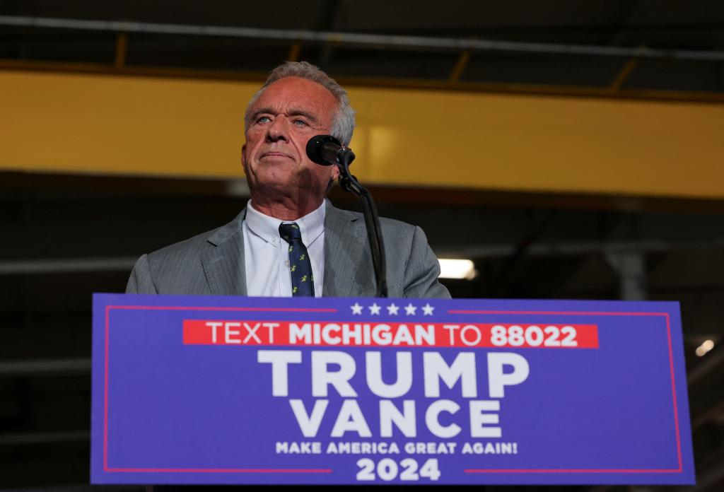 Robert F. Kennedy Jr. speaking into a microphone during Donald Trump's campaign stop at FALK Production in Walker, Michigan