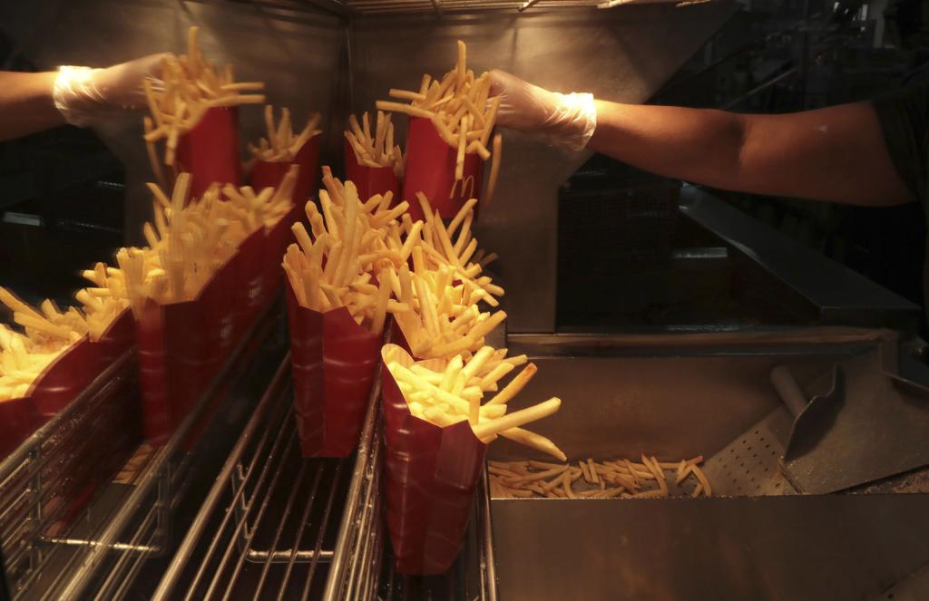 A hand filling orders of French fries at a Chicago McDonald's location