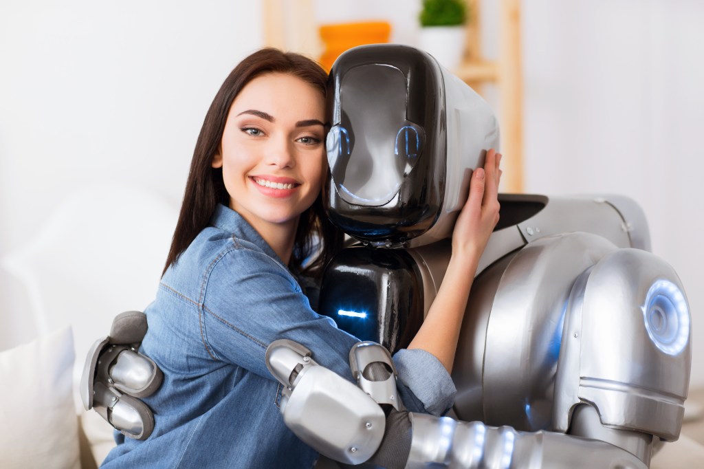 A woman hugging a robot. 