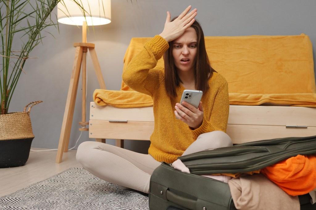 A woman angrily looking at her phone. 