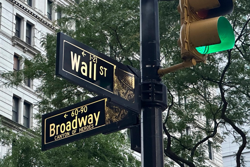 Signs marking intersection of Wall St. and Broadway.